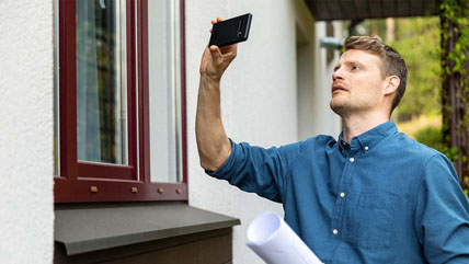 Man inspecting home and taking photos