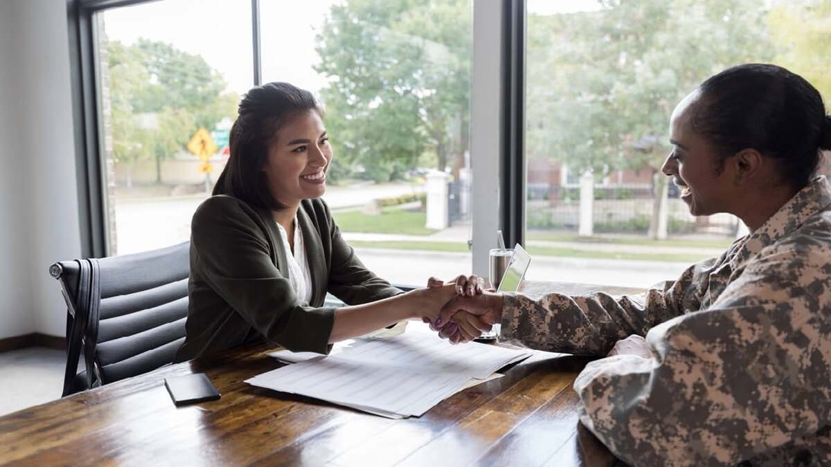 A veteran shakes hands with another woman